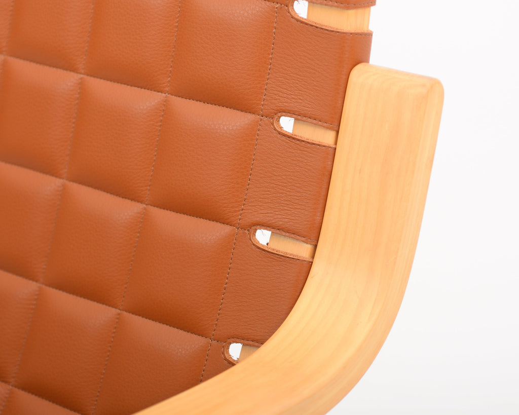 Detailed close-up showing the birch armrest and finely upholstered leather seat.