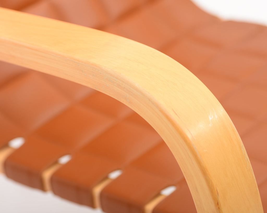 Detailed close-up showing the birch armrest and finely upholstered leather seat.