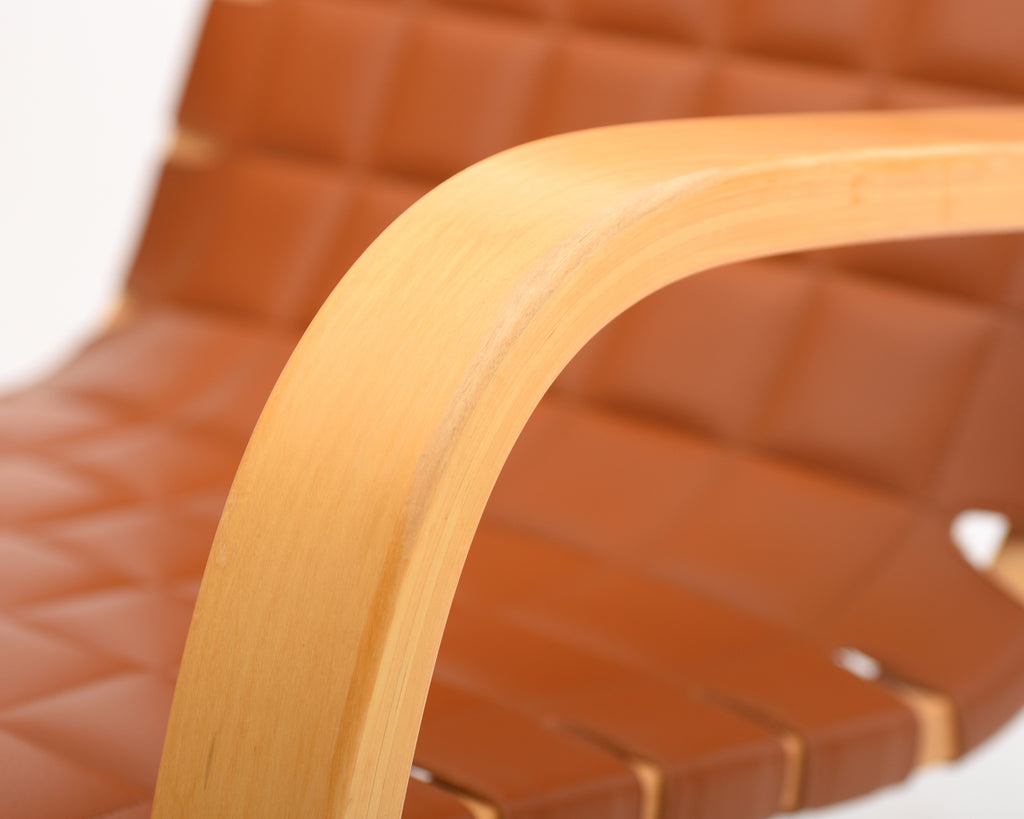 Detailed close-up showing the birch armrest and finely upholstered leather seat.