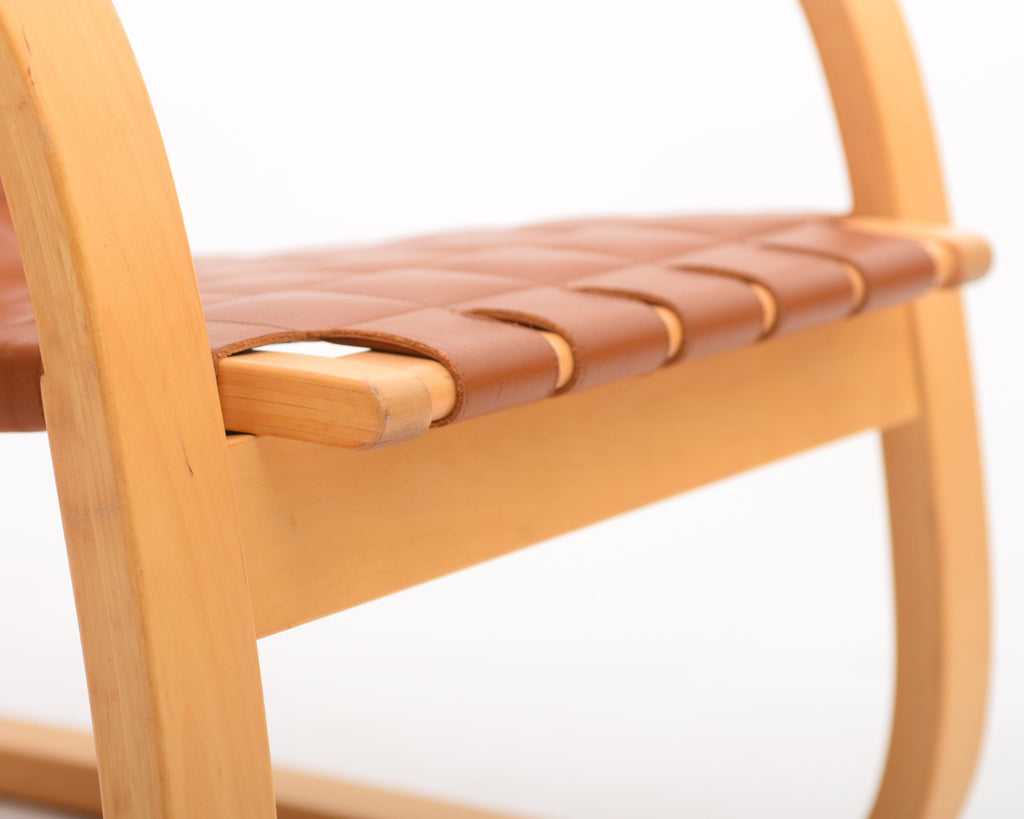 Front view of the armchair highlighting the edge of the leather-upholstered seat.