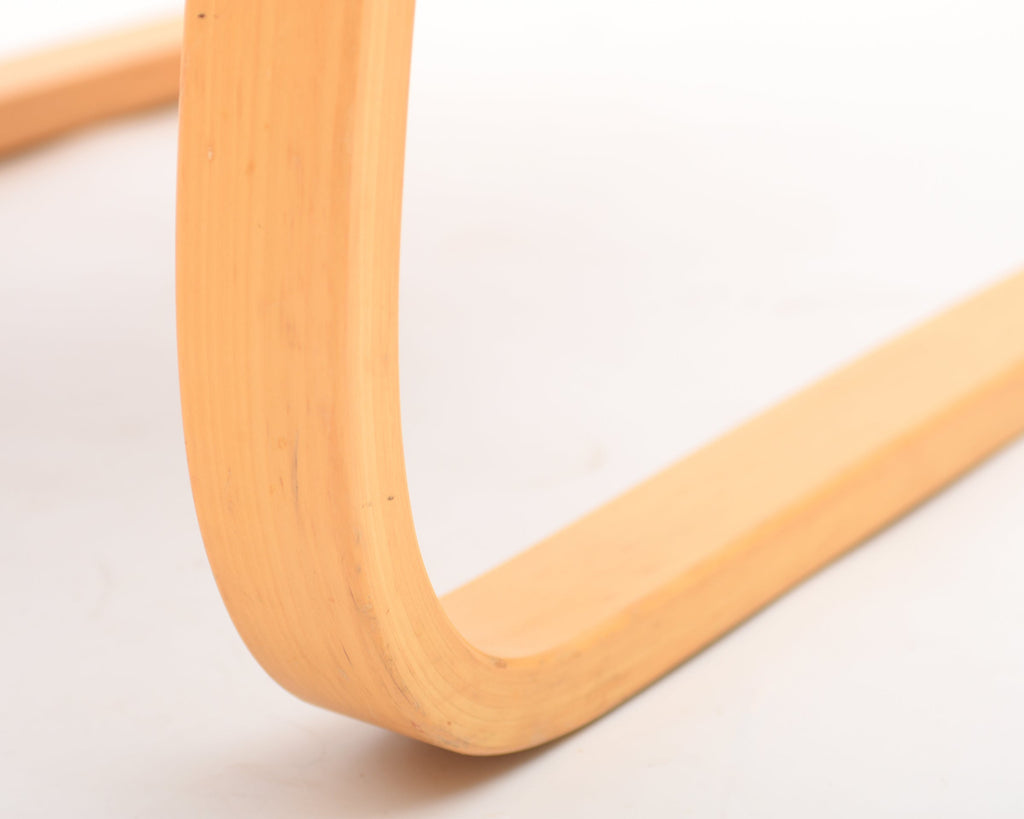 Close-up of a wooden chair leg on a light background.