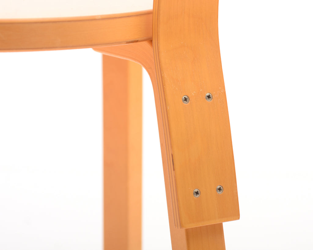 Close-up of a chair backrest attached to the rear leg with screws.