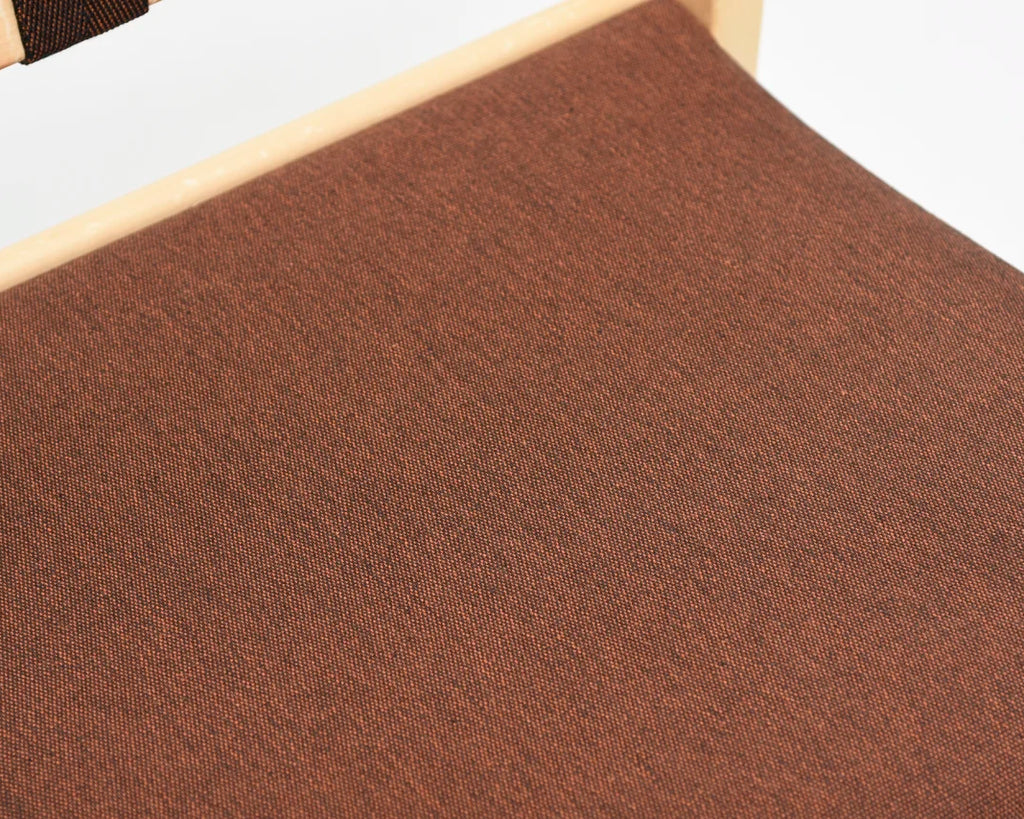 Detailed close-up of the chair seat with brown fabric upholstery.