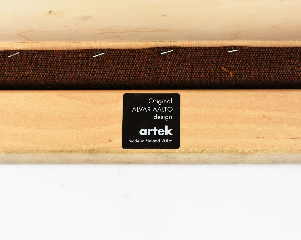 Detail view of the underside of the chair seat featuring a black and white Artek label from 2006.