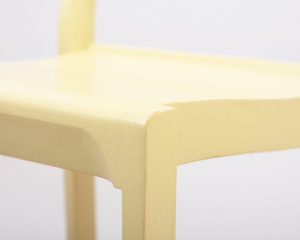 Close-up of a yellow chair on a white background.