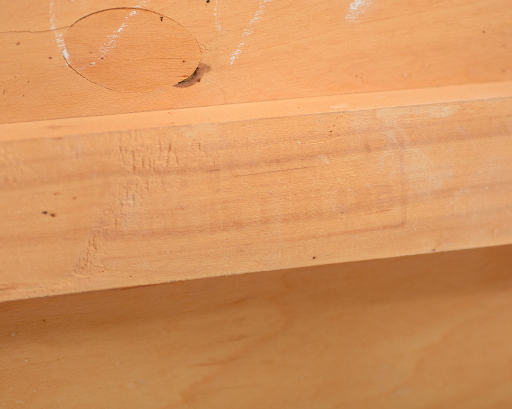 Close-up view of the underside of the Alvar Aalto 611 chair’s seat, showing the unpainted wooden surface.