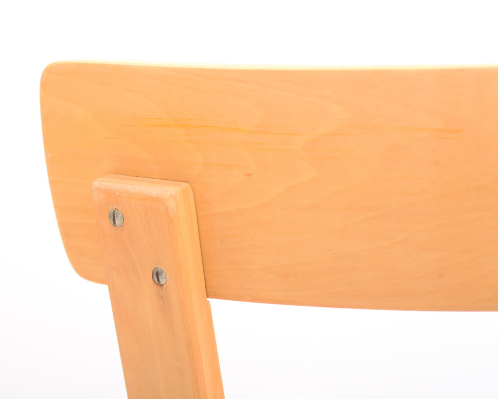 Close-up of a wooden chair backrest with visible screws on a white background.