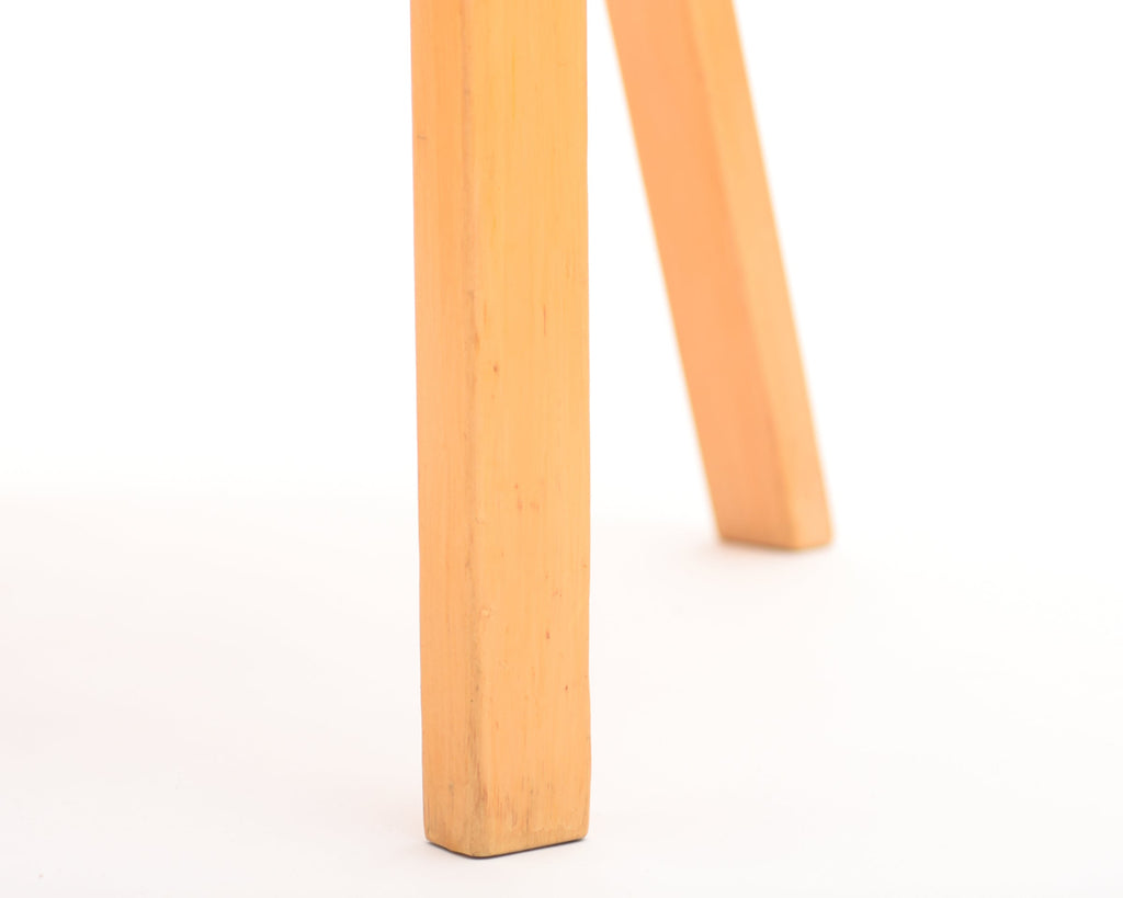 Close-up of a wooden chair leg on a white background.