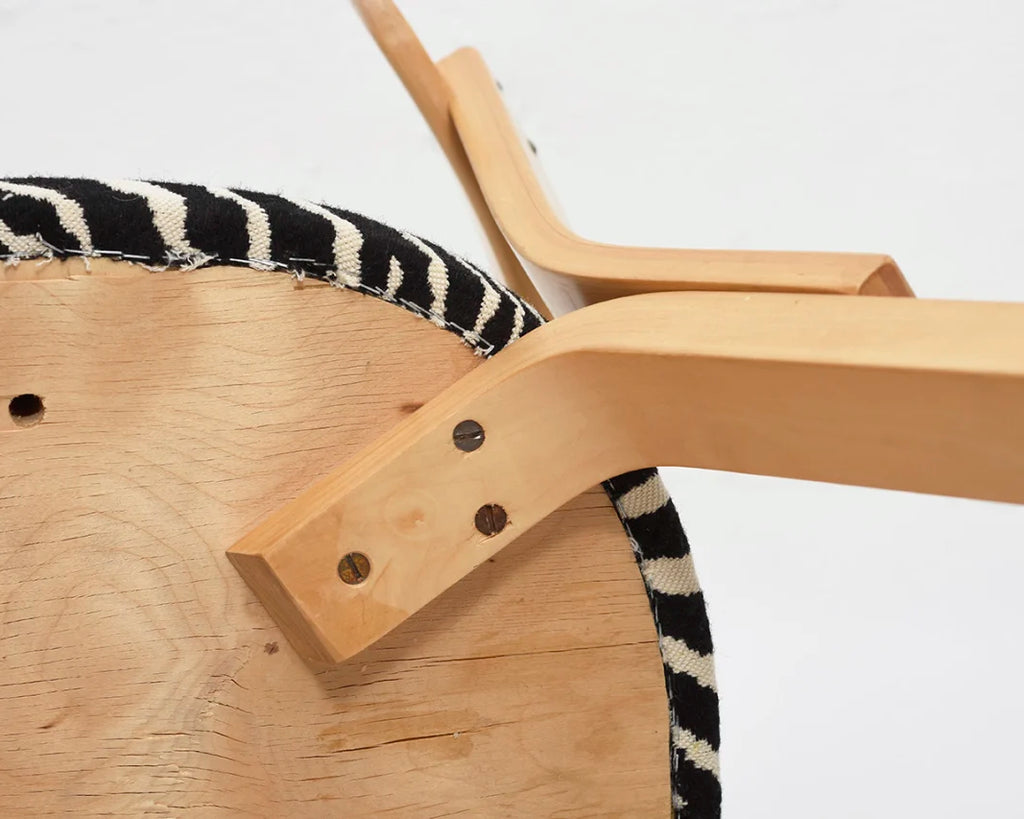 Close-up of the underside of the chair, showing how the Zebra fabric upholstery is attached to the seat.