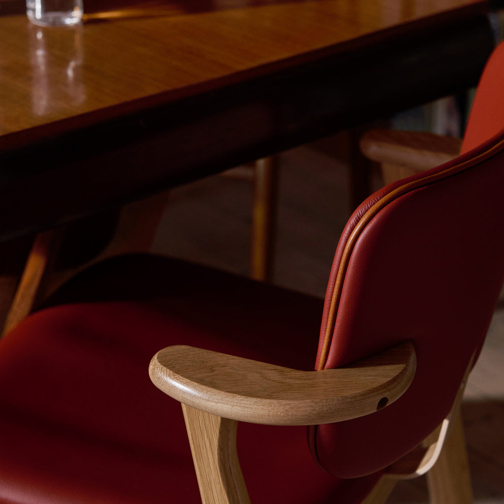 Close‑up side view of the Domus Chair’s backrest, highlighting the Spectrum Terracotta leather upholstery and the contrasting Prestige Cognac leather piping.
