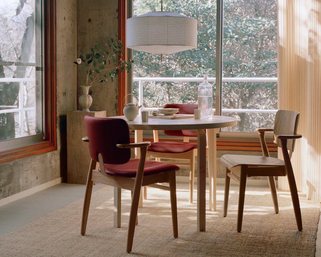 Minimalist, Japanese‑inspired room with a round table surrounded by three Domus chairs.