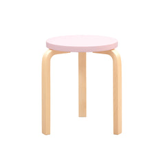 Product image of the Stool 60 with a pale pink painted seat and legs in clear lacquered birch. The stool is photographed against a white background.