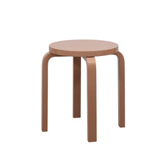 Alvar Aalto’s four‑legged E60 Stool in a terra‑colored finish.