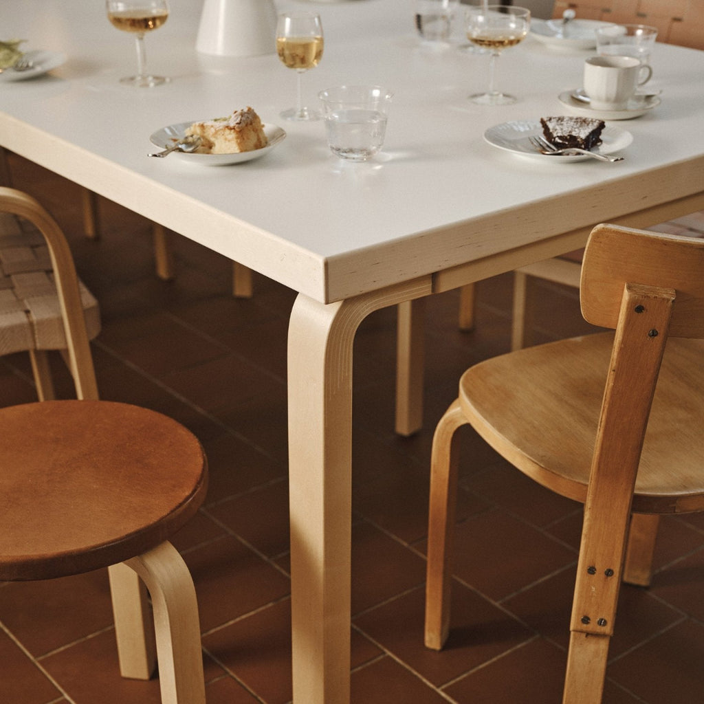 A close-up view of an Aalto table and Chair 69 in an atmospheric dining setting.