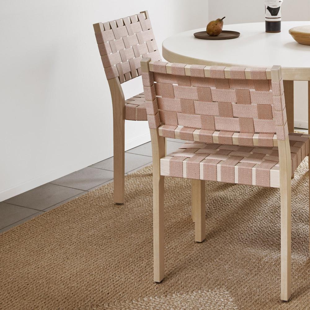 Close-up interior view of a dining set featuring a round Aalto Table 91 with a white laminate top. Two Chair 611 are placed around the table.