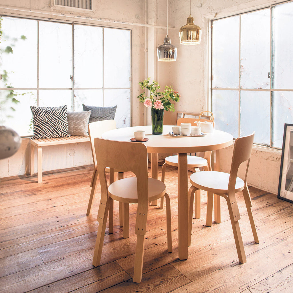 Dining area featuring a round dining table 91A surrounded by Chair 66. A slatted Bench 153A is positioned nearby, and two Pendant Lights A330S hangs above the table.