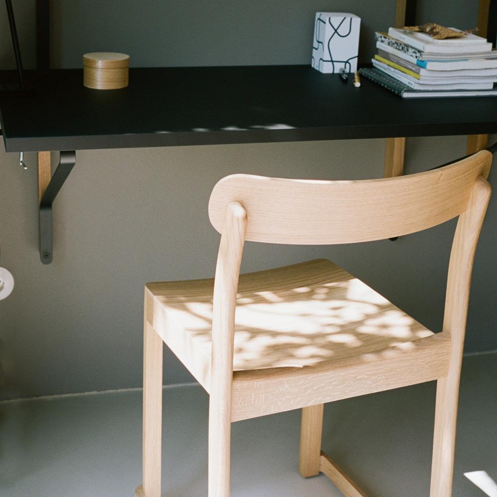 Interior view of a workspace featuring Kaari shelf with desk, paired with Atelier Chair.