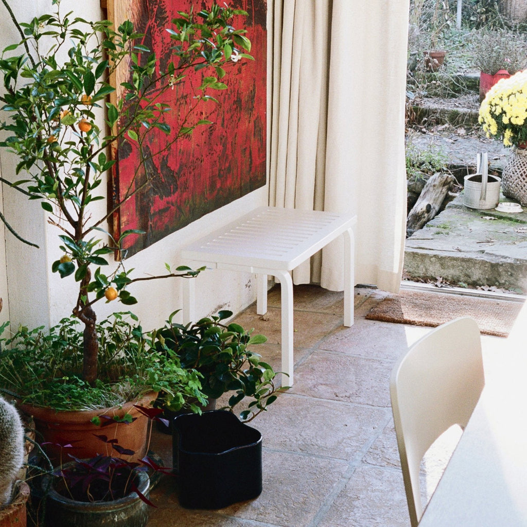 Interior view featuring a white lacquered Bench 153 with a slatted top placed against a wall.