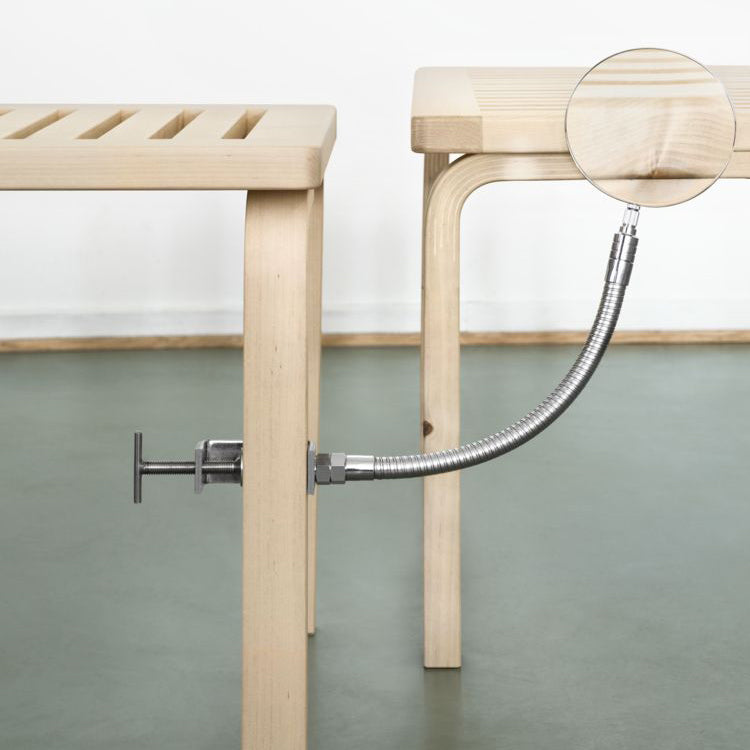 Interior view featuring two Bench 153A with slatted top in wild birch. One bench is shown with a magnifying glass highlighting characteristic features of wild birch, such as knots, insect marks and darker heartwood details.