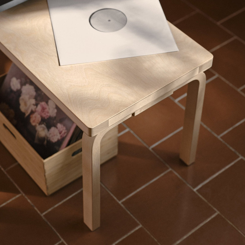 Close-up interior view of a birch Bench 153 with a solid top. A vinyl record is placed on the surface of the bench.