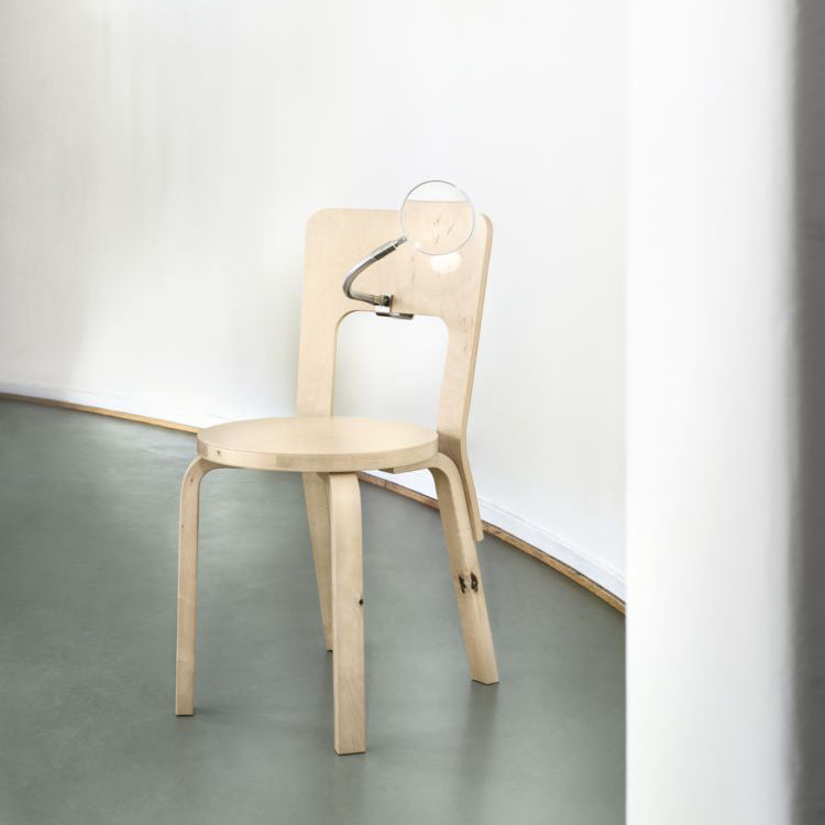 Interior view featuring Chair 66 in wild birch with a magnifying glass highlighting the material details.