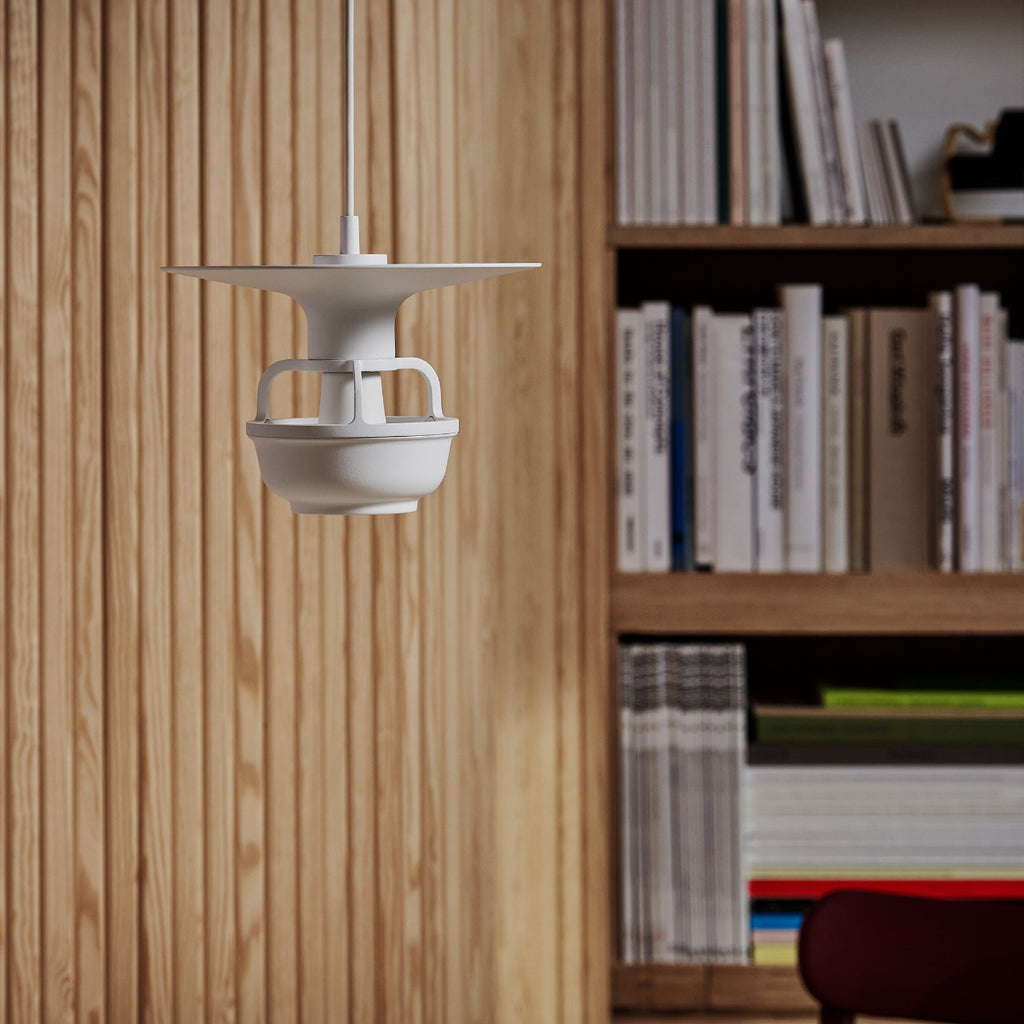 Interior view featuring Kori Pendant Light with Disc Shade. A bookcase filled with books is visible in the background, along with part of Screen 100.