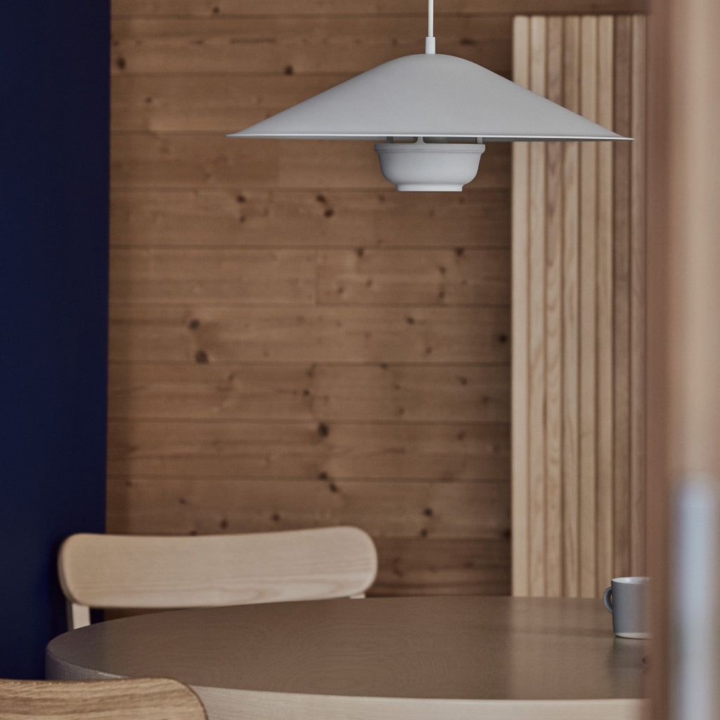 Interior view featuring Kori Pendant Light with Dune Shade placed on round Aalto Table 91. Atelier Chairs surround the table, with Screen 100 visible in the background. The light is switched off.