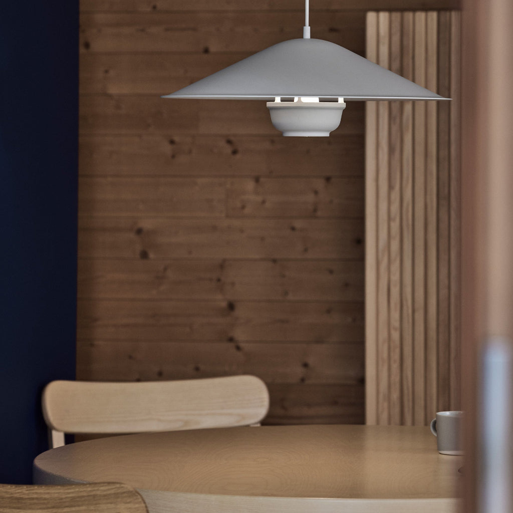 Interior view featuring Kori Pendant Light with Dune Shade placed on round Aalto Table 91. Atelier Chairs surround the table, with Screen 100 visible in the background.