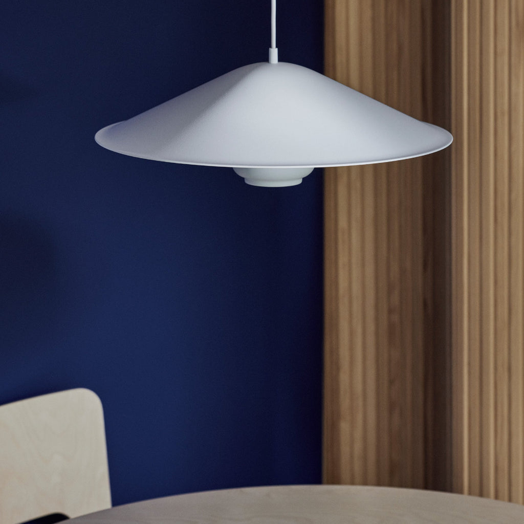 Interior view of a dark blue space featuring Kori Pendant Light with Dune Shade placed on a table. Screen 100 is visible in the background.
