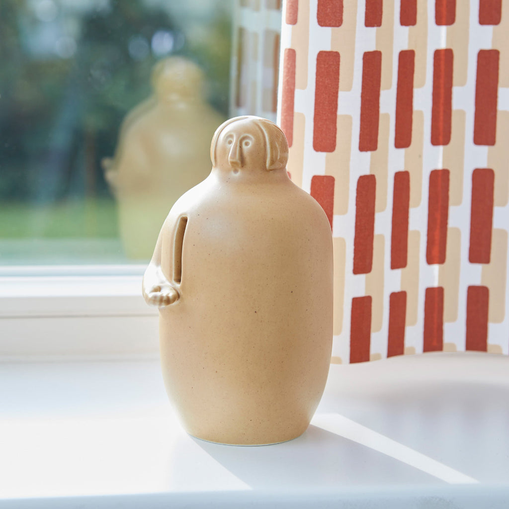 Close-up interior view featuring Pauper Coin Collector placed on a windowsill. Siena fabric curtain is visible in the background.