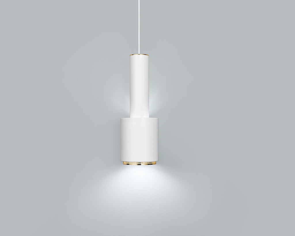Product image of white Artek Pendant Light A110 “Hand Grenade” with a brass ring detail. The pendant light is switched on and photographed against a grey background.
