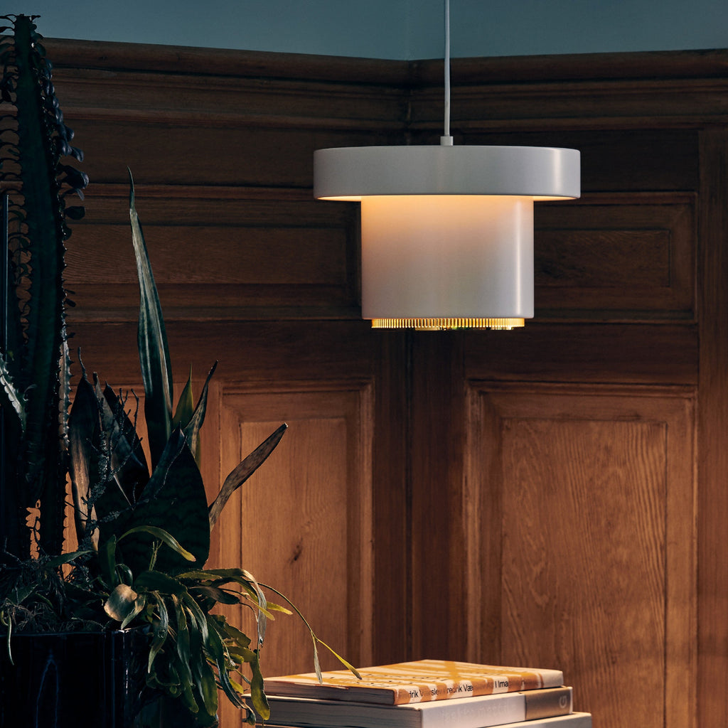 Interior view of a dimly lit hallway featuring a Pendant Light A201 placed on a side table. The light is switched on, creating a soft glow in the space.