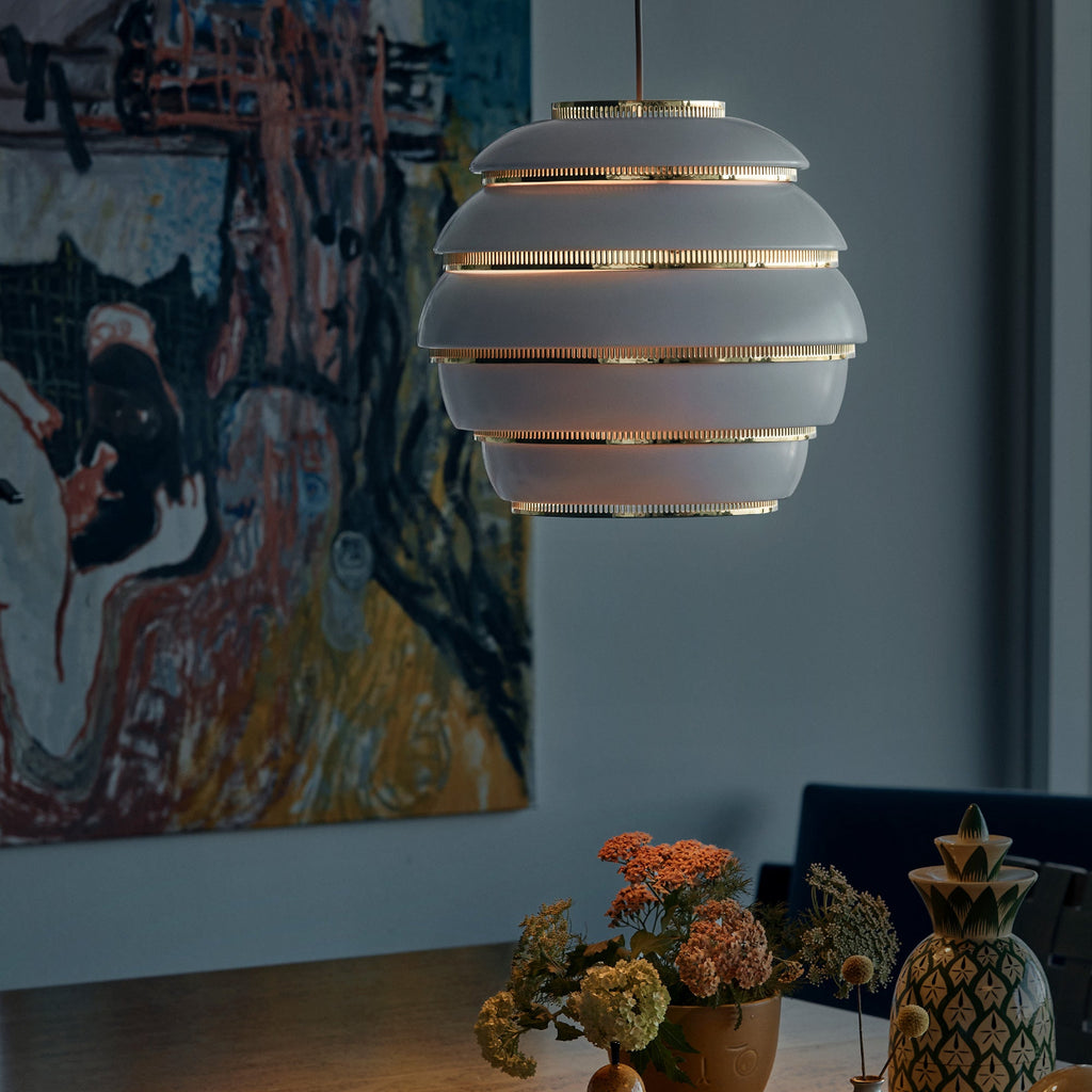 Interior view featuring a white and brass Pendant Light A331 “Beehive” switched on in a darkened room.