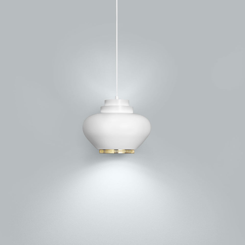 Product image of white Artek Pendant Light A333 “Turnip” with a brass ring. The pendant light is switched on and photographed against a grey background.