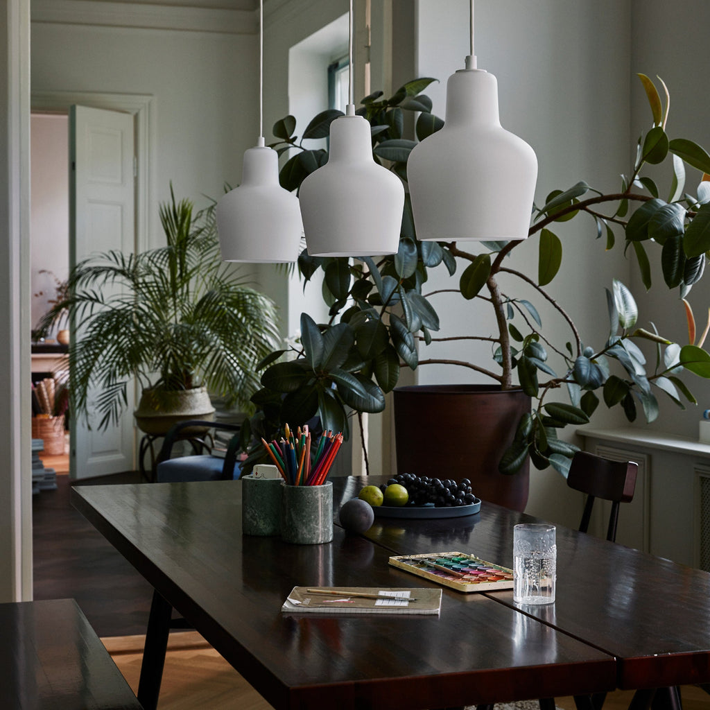 Interior view of dining area lit by daylight featuring Pirkka Table with three Pendant Light A440 switched off above it.