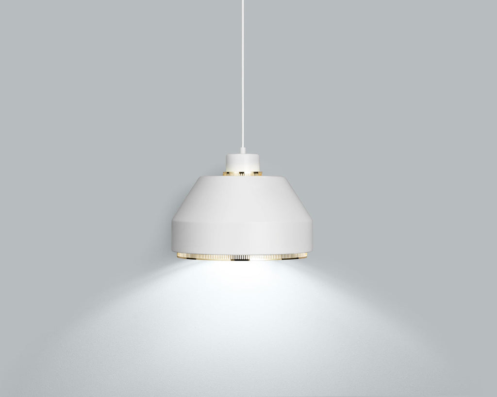 Product image of white Artek Pendant Light AMA500 with brass details. The pendant light is switched on and photographed against a grey background.
