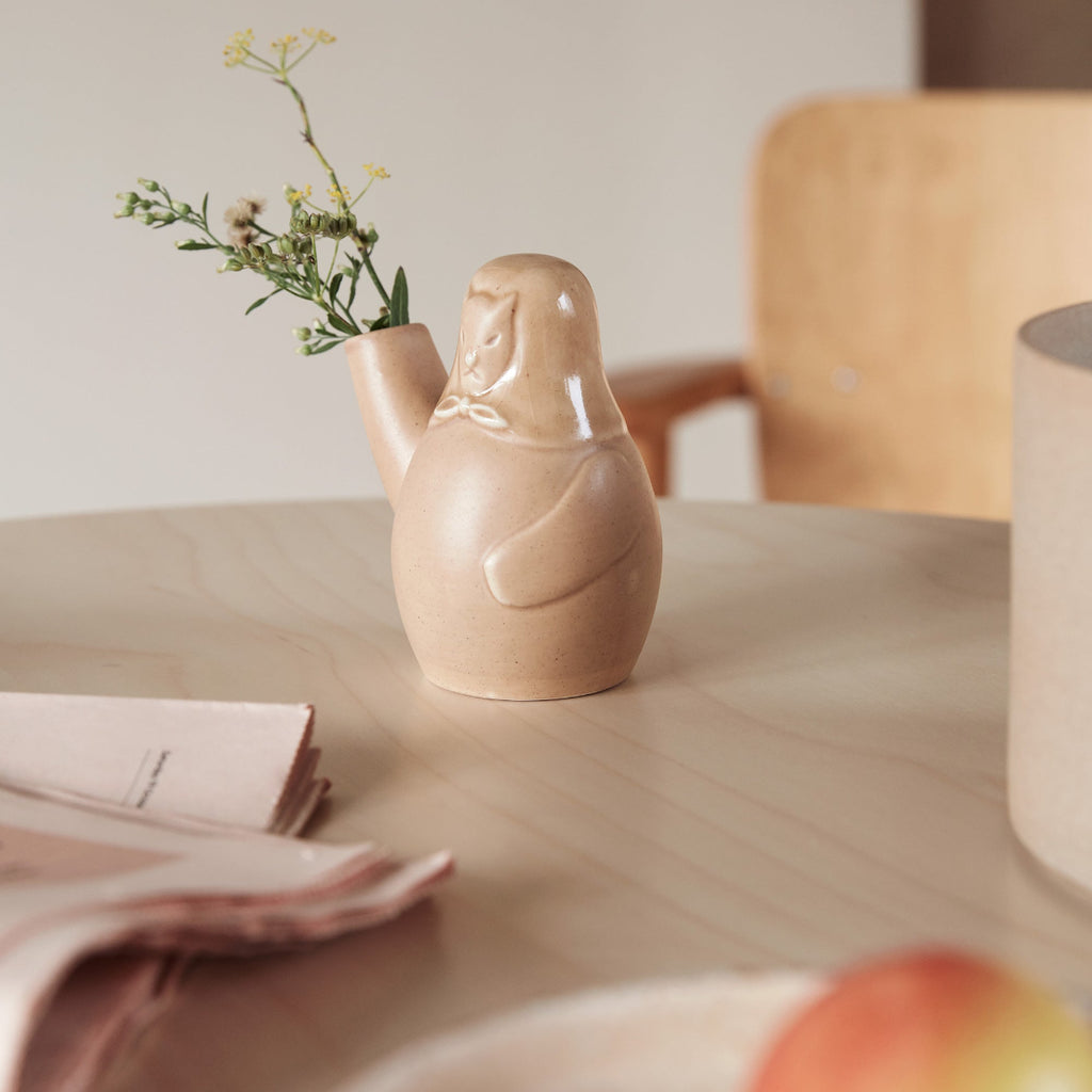 Close-up interior view featuring Easter Dog Vase placed on a table, with a few flowers arranged inside.