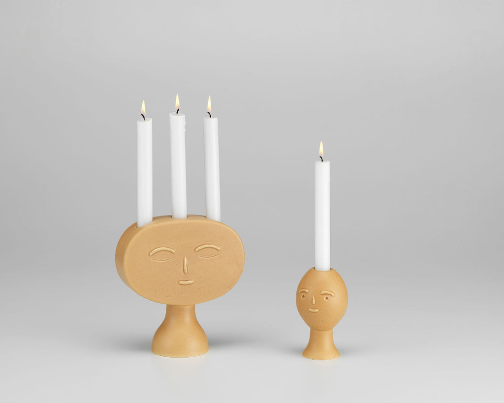 Product image of Artek Secrets of Finland Lucia and Lucius Candleholders displayed together, with the candles lit.