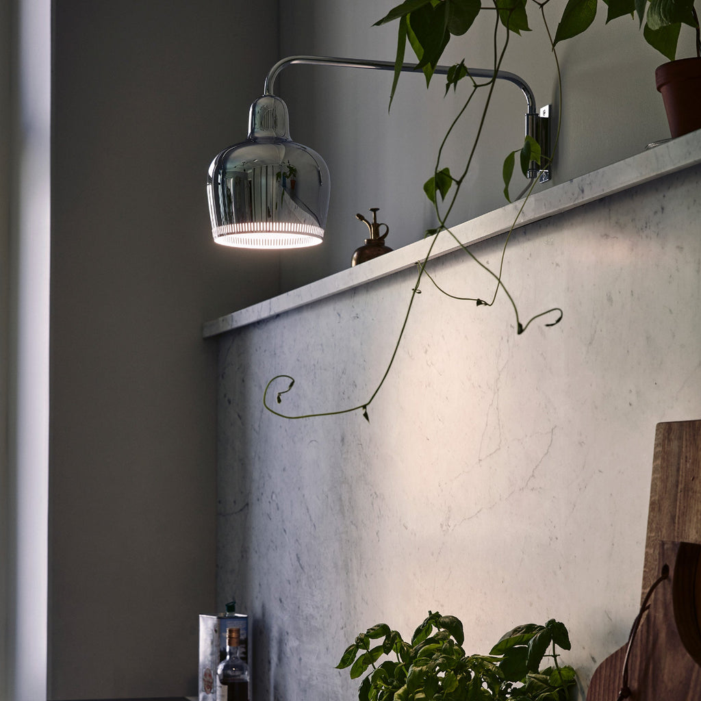 
Interior view of a kitchen featuring chrome Wall Light A330S mounted above a marble worktop. The light is switched on.
