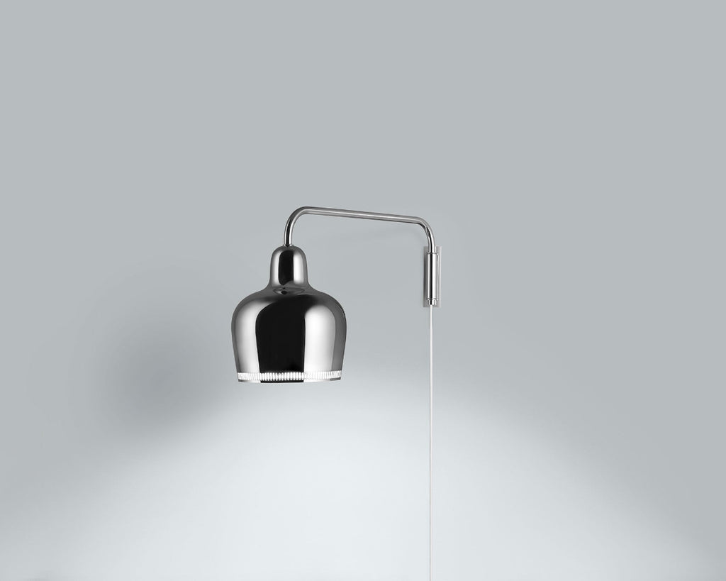 Product image of chrome Artek Wall Light A330S “Golden Bell”. The wall light is switched on and photographed against a grey background.