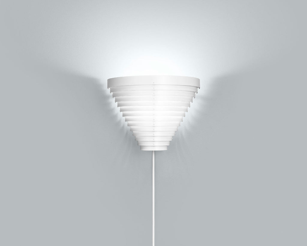 Product image of white Wall Light A910 mounted on a grey wall. The wall light is switched on, emitting a soft glow.